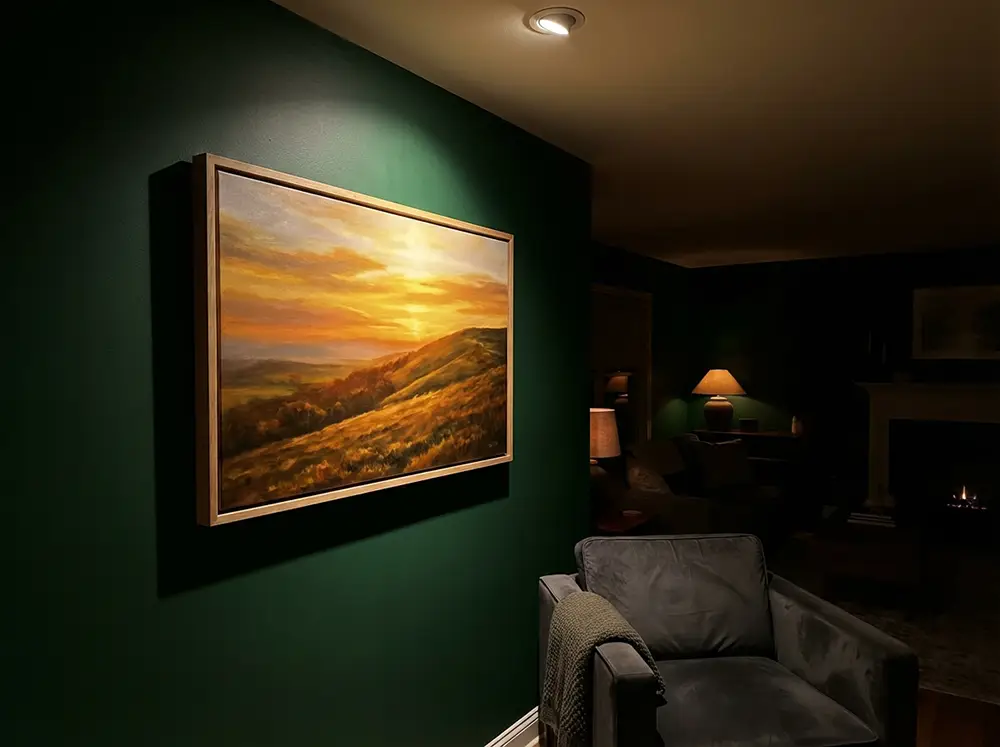 Grand tableau aux tons chauds dorés accroché sur un mur vert forêt dans un intérieur cosy